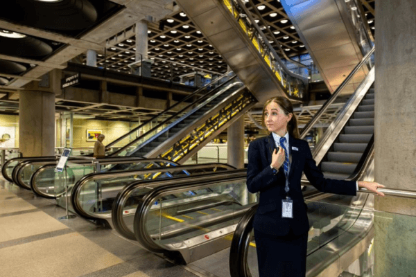A security officer standing by an escalator